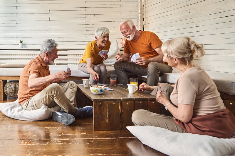 Medicare Advantage customers playing cards and eating snacks.