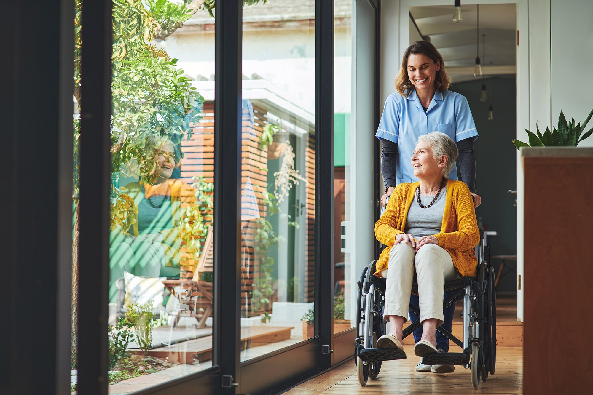 Nurse pushes older woman in a wheelchair Nurse pushes older woman in a wheelchair