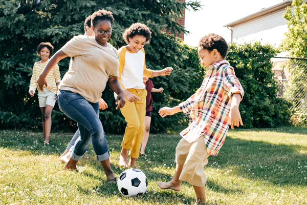 Family playing soccer in backyard Family playing soccer in backyard