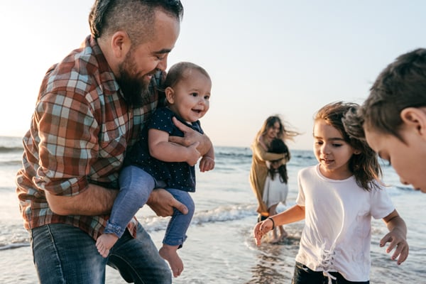 Father playing with children on beach