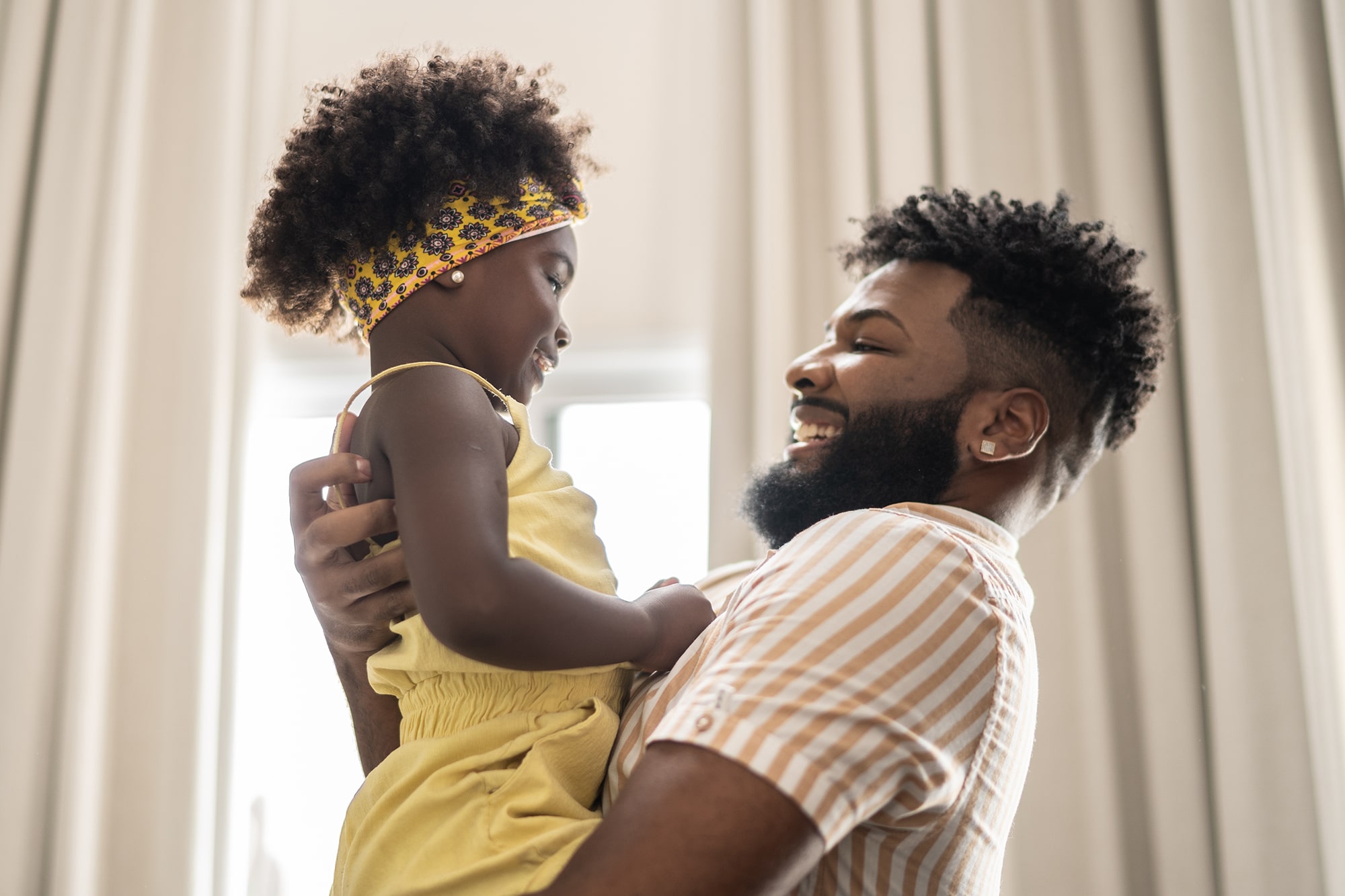 Man holds daughter in arms Man holds daughter in arms