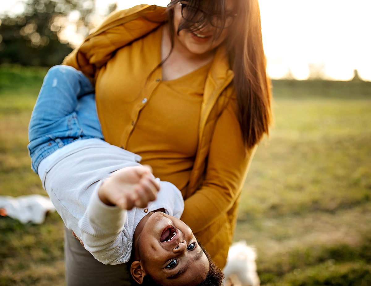 Woman holding boy upside down